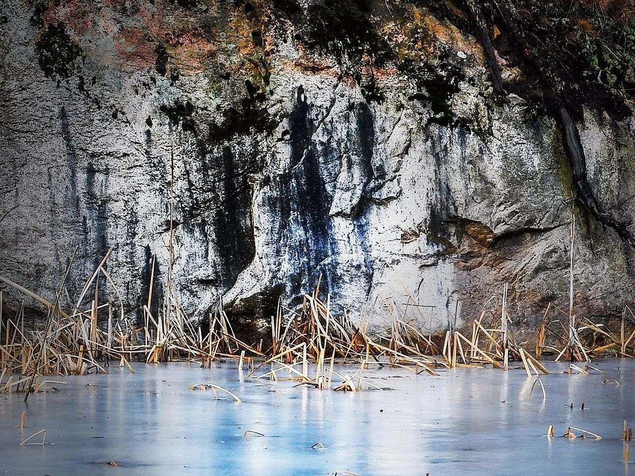 Pescatori con attrezzatura da pesca invernale ai margini del lago tra le montagne